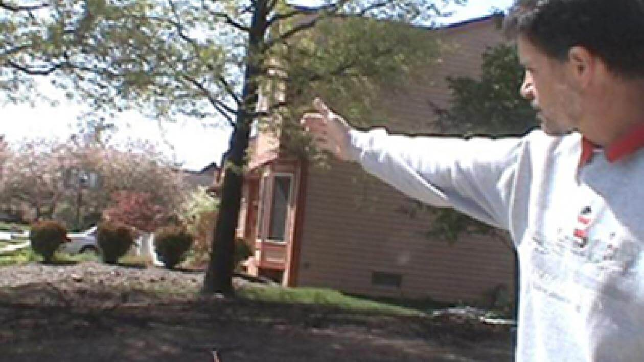 A man pointing in the direction of a dirt patch