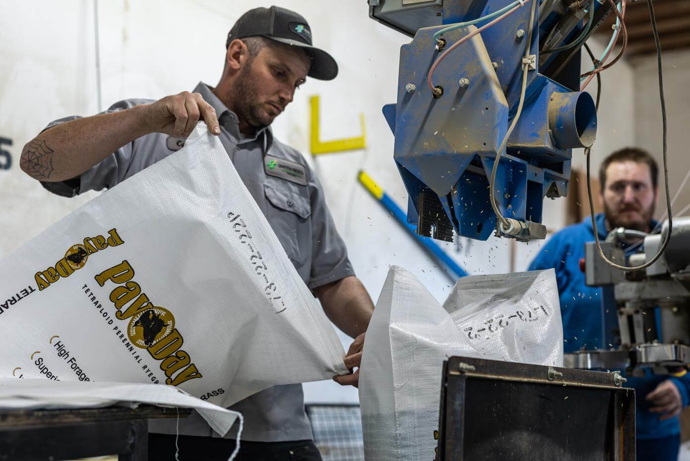 Man pouring seed into a machine.