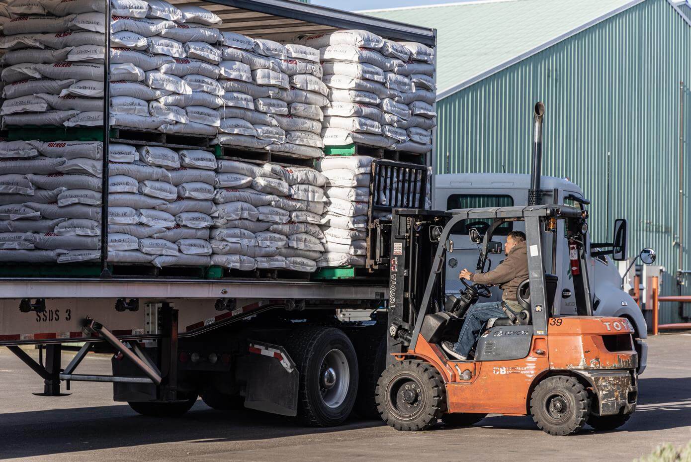 Forklift loading seed onto semi.