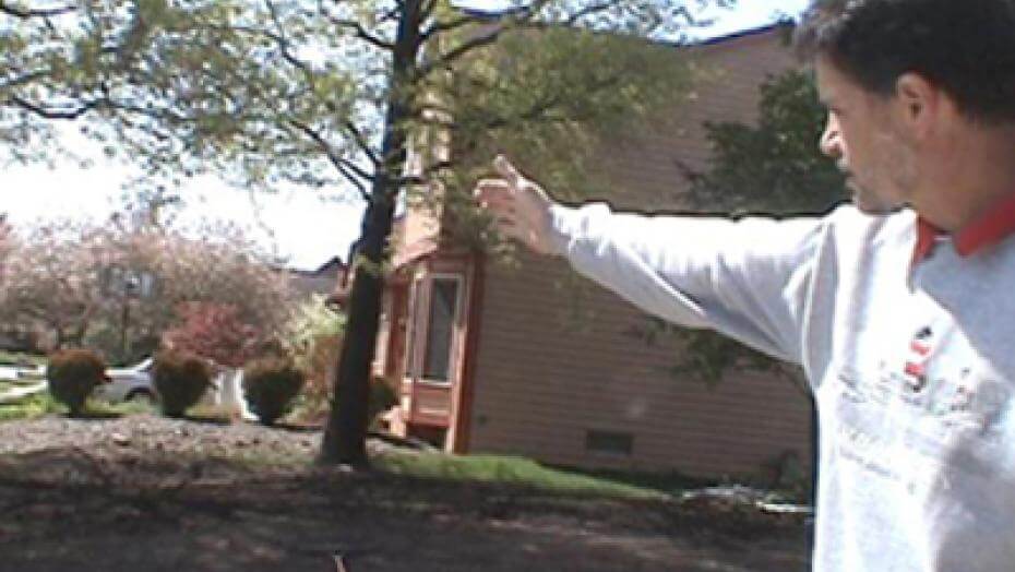 A man pointing in the direction of a dirt patch